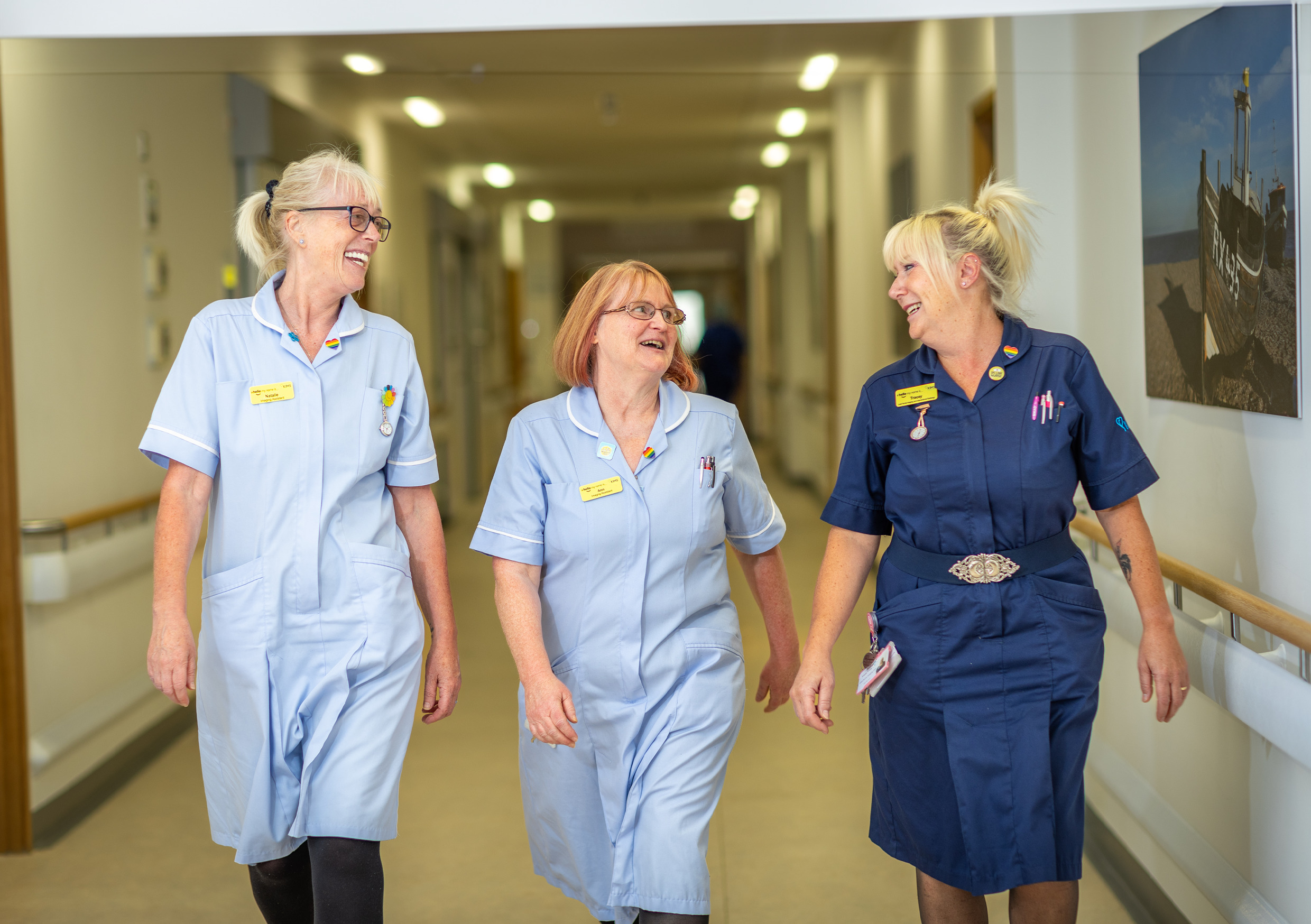 Three nurses walking down a corridor