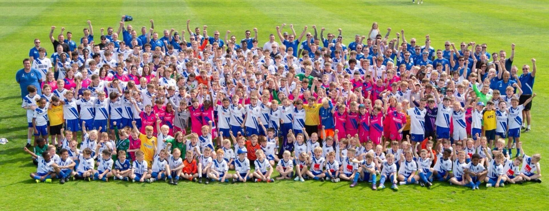 Large group photo of Bearsted FC players, coaches and youth teams on the football pitch celebrating together, marking the club’s renewed medical partnership with KIMS Hospital for the 2025/26 season.