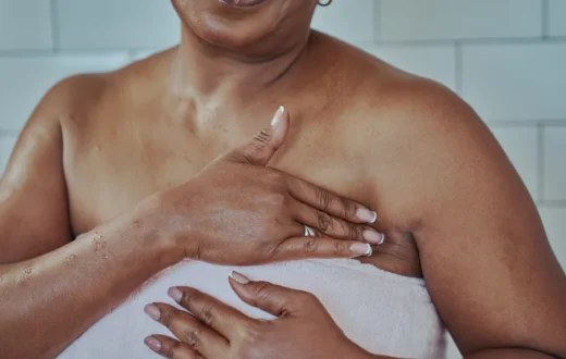 Woman checking her breast and chest after getting out of the shower